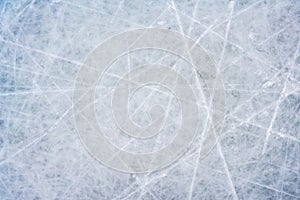 Ice background with marks from skating and hockey, blue texture of rink surface with scratches