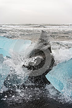 Ice blocks on the beach with water splashes