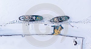 Ice bound ships froze in snow in winter, waiting for breaker, aerial top view