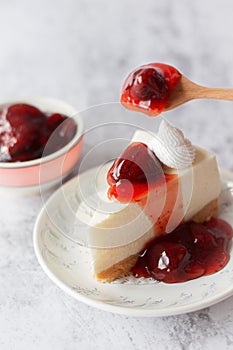 Ice box cheese cake with strawberry jam and whipping cream on white background