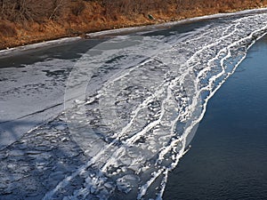 Ice Buildup On Shore Of River In Autumn