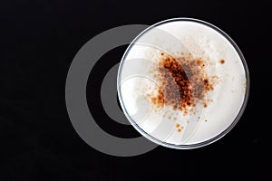 Ice cappuccino in plastic cup. Top view of milk foam and cinnamo