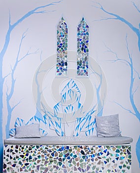 Ice castle interior. Two stained glass windows in the medieval style. Blue trees on the wall. Throne sofa made of snow.