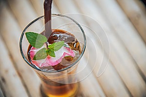 Ice chinese tea in glass with wood background decorate with rose