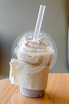 Ice chocolate frappe and whipped cream in the takeaway plastic cup