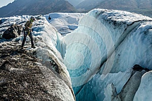 Ice climber looking into a huge crevasse on the Matanuska Glacier