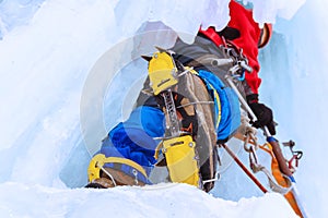 Ice climber on a vertical wall of a frozen waterfall, bottom up view