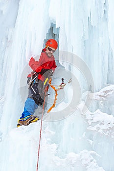 Ice climber on the vertical wall of the glacier