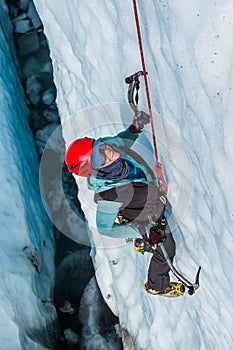 Ice climbing guide down inside a deep crevasse filled with water