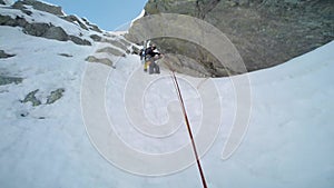 Ice climbing: mountaineer on a mixed route of snow and rock duri