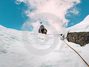 Ice climbing: mountaineer on a mixed route of snow and rock during the winter