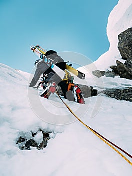 Ice climbing: mountaineer on a mixed route of snow and rock during the winter