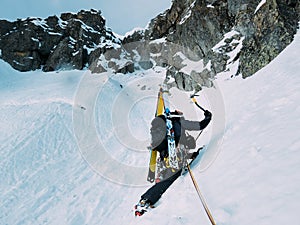 Ice climbing: mountaineer on a mixed route of snow and rock during the winter