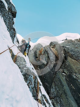 Ice climbing: mountaineer on a mixed route of snow and rock during the winter