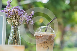 Ice coffee in clear plastic with dry flowers