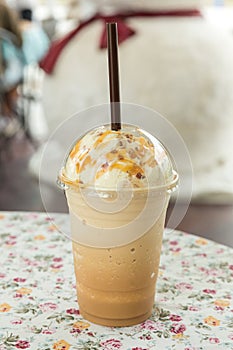 Ice coffee with cream on table. Caramel frappe coffee in the coffee shop.