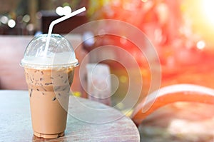 Ice coffee in plastic cup on Table in the garden