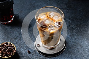 Ice coffee in a tall glass with cream poured over. almond milk latte. Cold summer drink. Cold brew in glass. vegetarian