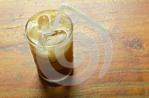 Ice coffee topping milk floating with straw in glass