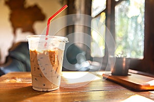 Ice coffee on wooden table at cafe windows morning