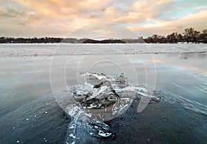 Ice composition at frozen lake Beloye in winter with a sunset background