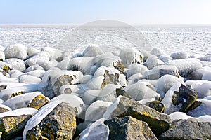 Ice covered stones under a blue sky