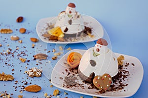 Ice cream background in the shape of two edible snowmen on white plates close up. Top view. Creative idea for Christmas.