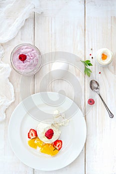 Ice cream with berries on white plate top view