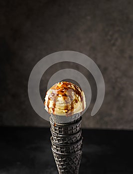 ice cream in a black cone with caramel