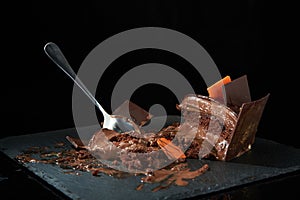 Ice cream chocolate cake on a black plate, meal start