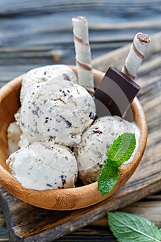 Ice cream with chocolate crumb in a wooden bowl.