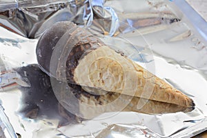 Ice-cream with chocolate icing in a wafer tube unpacked from foil