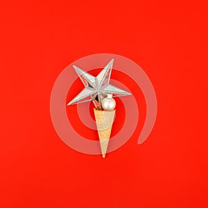 Ice Cream Cone with Christmas Decoration on traditional red Background. Minimal Christmas Concept. Flat Lay. Greeting card for