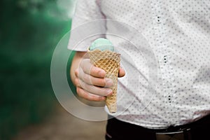 The ice cream cone is in the hands of a man. Ice cream in hands