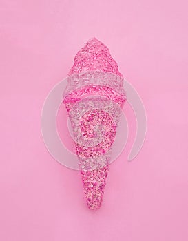 Ice cream cone made from confetti with tasty cream on pink paper background. Trendy minimal pop art style and summer food concept.