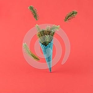 Ice cream cone with pine branch on red background