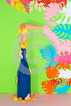ice cream cone with rose petals melting and falling in a blue bottle on a green background