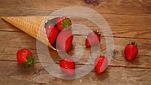 Ice cream cone with strawberries on a wooden background