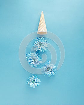 Ice cream cone upside down with soft blue flowers like ice cream. Spring summer sunny days concept idea