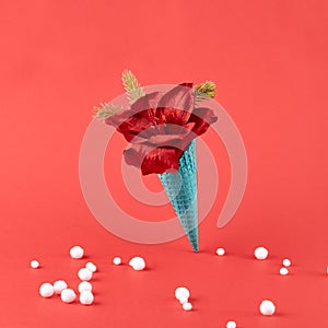 Ice cream cone with xmas flower and pine branch on red background