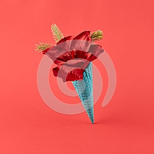 Ice cream cone with xmas flower and pine branch on red background