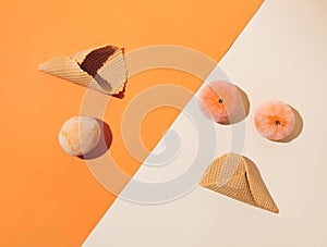 Ice cream cones with frozen summer fruit on orange and beige background. Minimal summer food concept. Flat lay