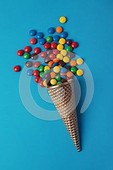 Ice cream in cornet with colorful bonbons