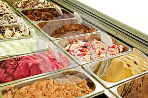 Ice cream fridge with creamy and fruit Italian ice cream steel serving counter with many of refreshing sweet scoopable flavors.