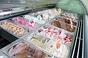 Ice cream fridge with creamy and fruit Italian ice cream steel serving counter with many of refreshing sweet scoopable flavors.