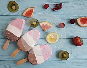Ice cream fruits on a blue wooden background, grapefruit, lemon, kiwi, pattern, strawberry