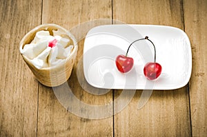 Ice cream in a glass with cherry in a white plate/ice cream in a glass with cherry in a white plate. Top view