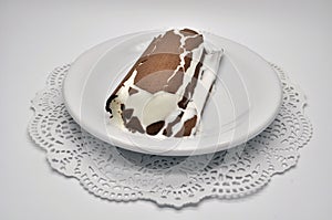 Ice-cream Lakomka ice-cream in melted chocolate on a white plate on a saucer with napkin isolated on white background