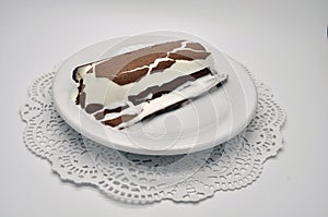 Ice-cream Lakomka ice-cream in melted chocolate on a white plate on a saucer with napkin isolated on white background