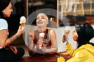 Ice cream and laughs. three friends enjoying ice cream cones while out in the city.